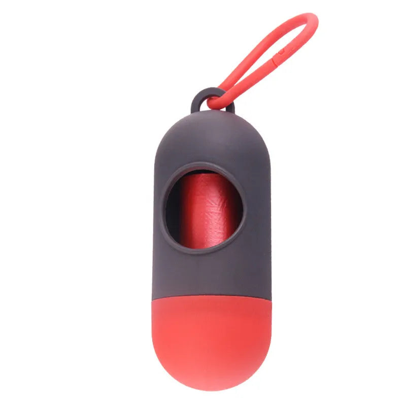 Compact black dog waste bag dispenser with a metal hook and Velcro strap, shown attached to a dog lead.
