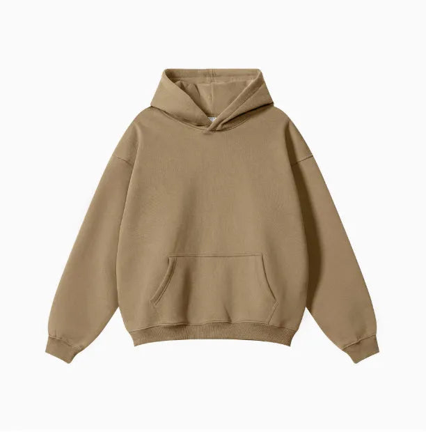 Man wearing a loose-fit grey cotton terry hooded sweater with drop-shoulder sleeves.