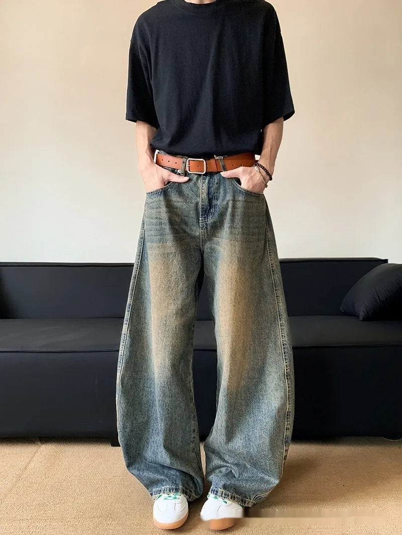 Men's retro blue distressed denim pants with a slim wide-leg fit and a zipper fly.