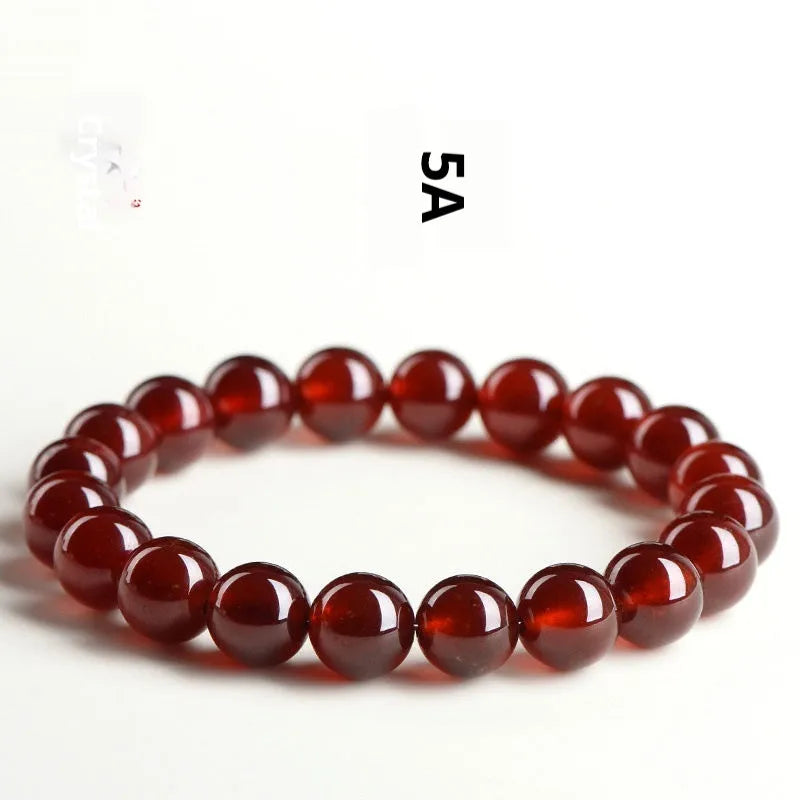 Natural orange red garnet crystal bracelet with Ruyi design elements on wrist