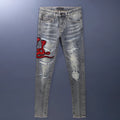 Men's slim fit jeans with a washed-out faded finish and embroidered patch details on the leg.