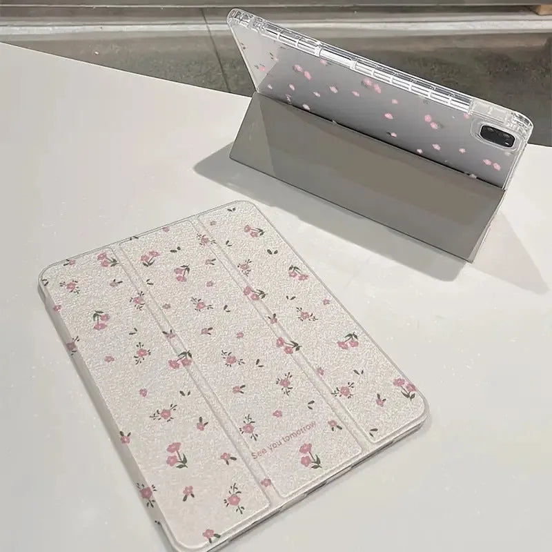 Transparent tri-fold iPad case with floral cartoon pattern, shown in standing position with magnetic closure