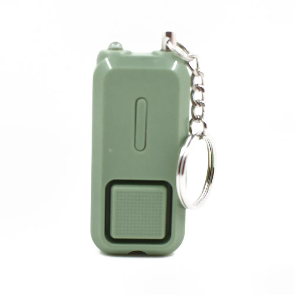 Compact pink personal safety alarm with keyring, showing dimensions next to a ruler.