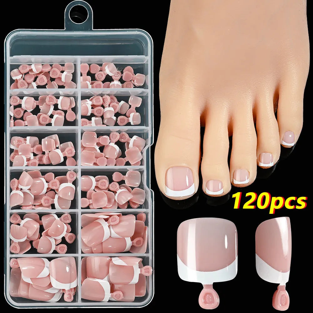 Box of 120 French white edge nude false toe nail pieces in assorted shades on a table