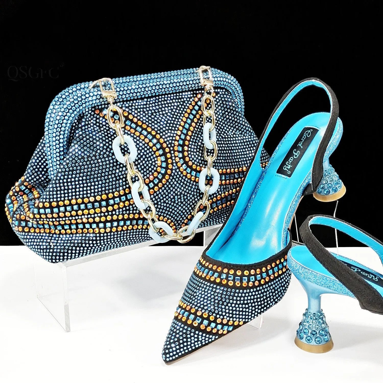 Women's pink pointed toe high heel shoes with rhinestones and a matching small clutch bag.