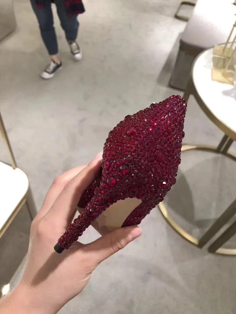 Gold women's high heel with pointed toe, rhinestones, and a stiletto heel on a white background.