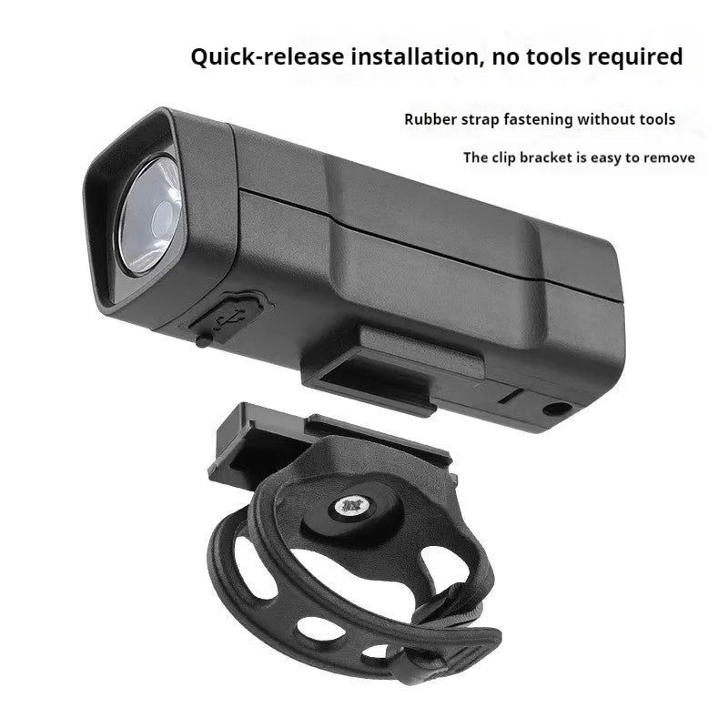 Black USB-rechargeable bicycle headlight with quick-release strap mount on handlebars.