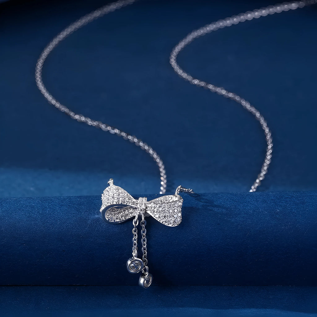 S925 sterling silver bow pendant necklace with O-ring chain on grey background