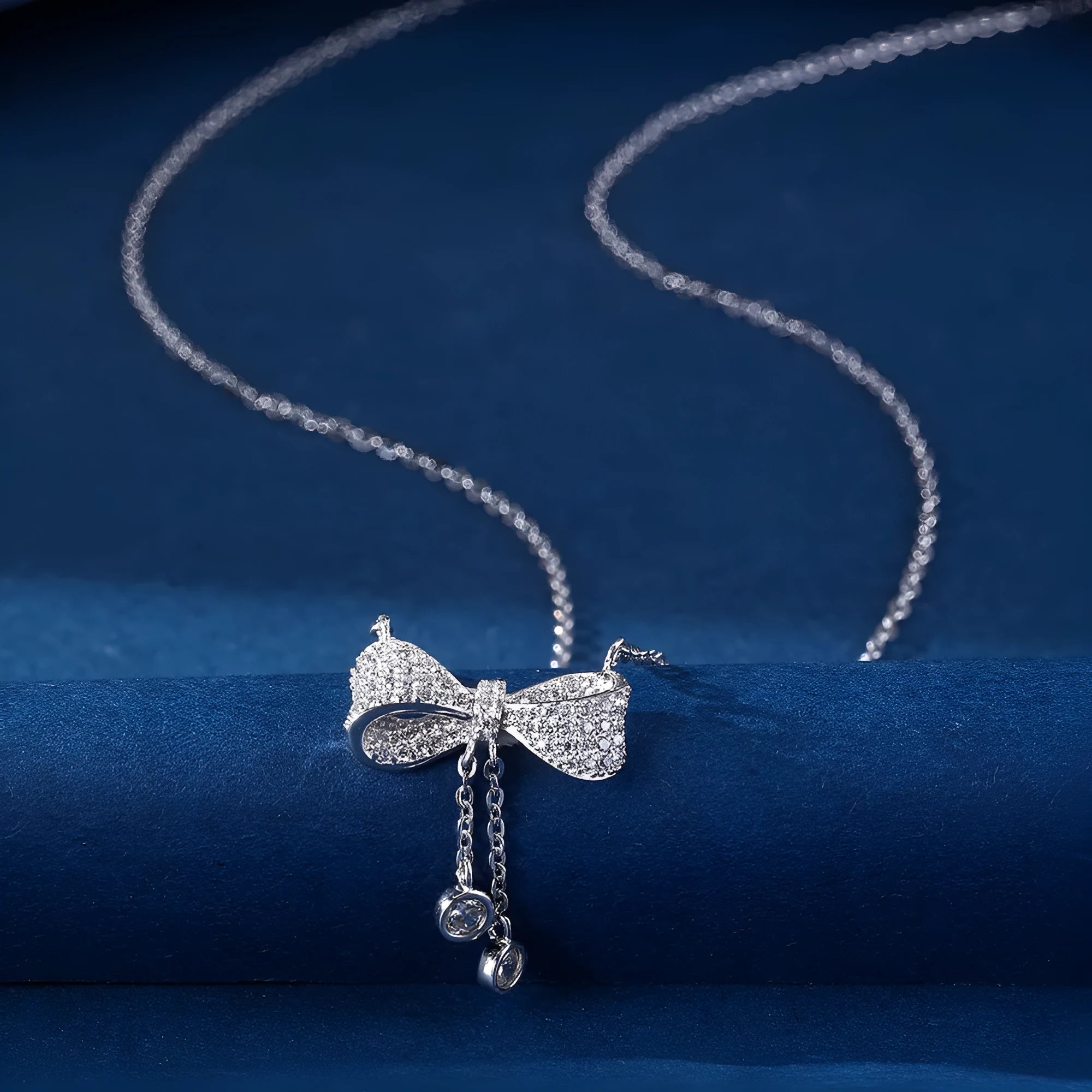 S925 sterling silver bow pendant necklace with O-ring chain on grey background
