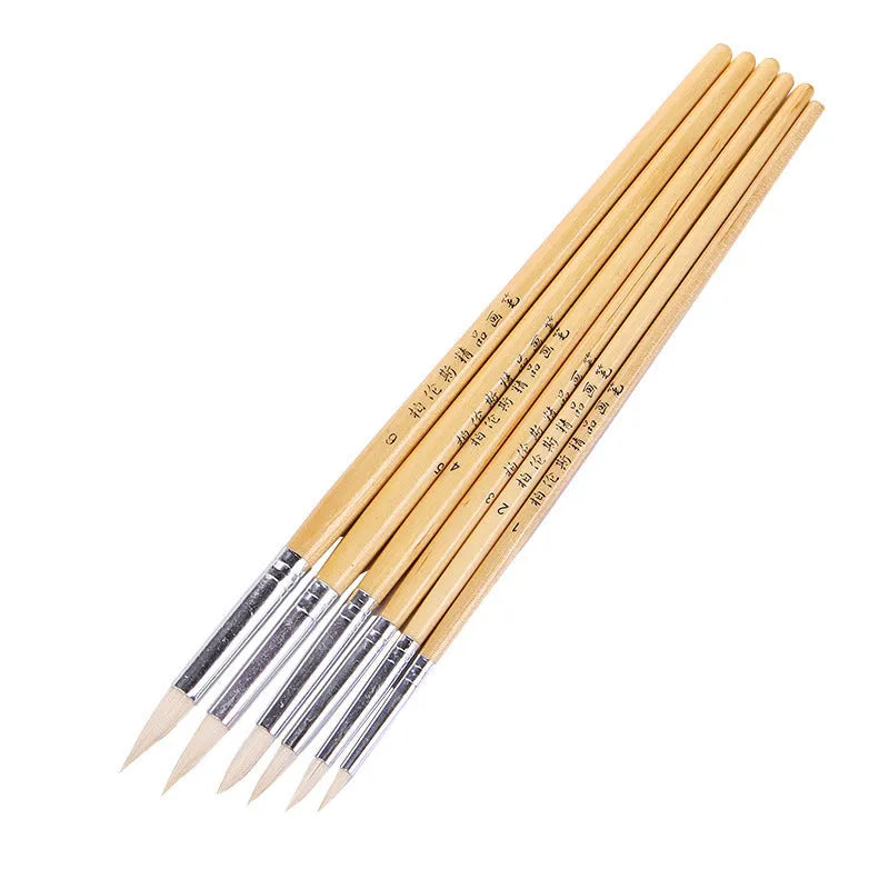 Six wooden pen brushes with pointed tips arranged together as an artistic brush set