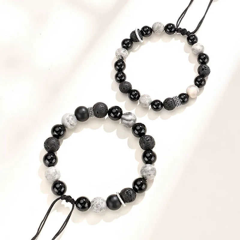 Black agate map stone and volcanic rock bracelet in diamond shape on a wrist.