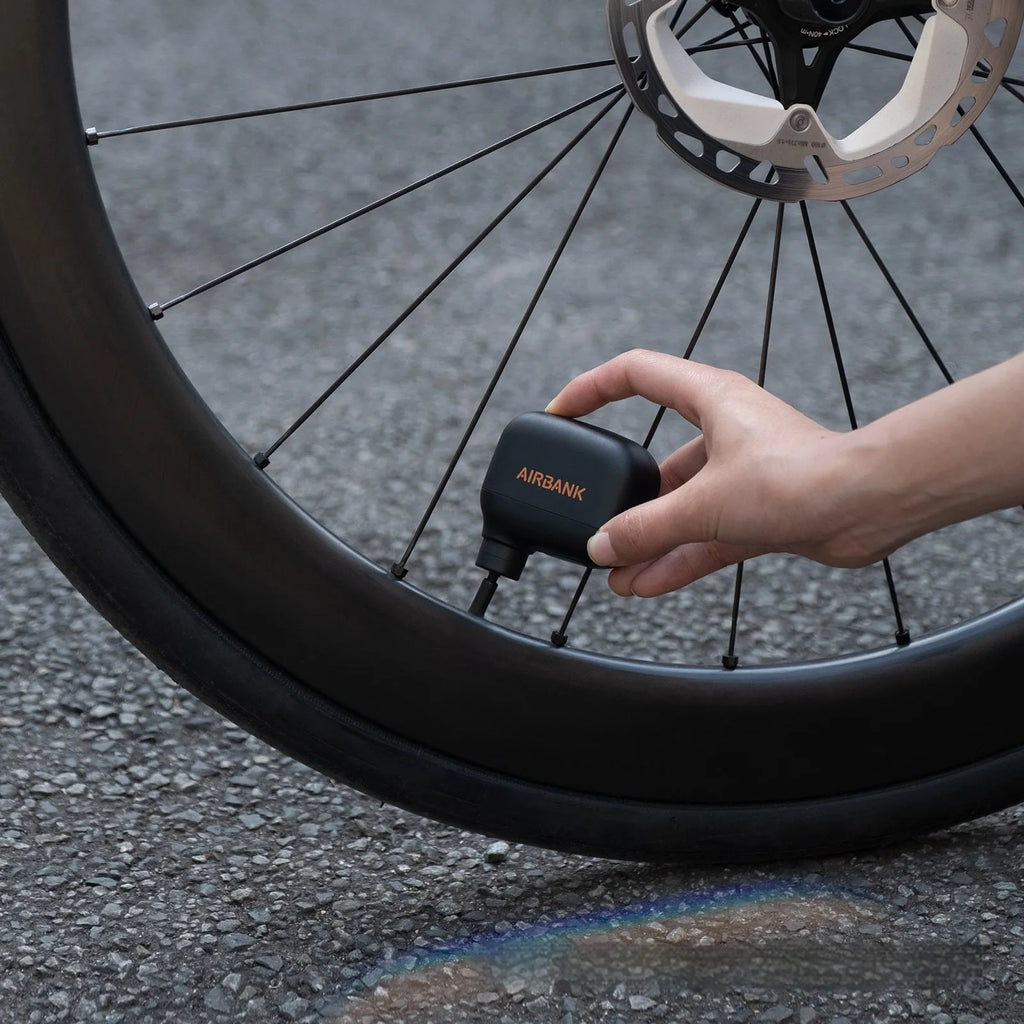 Black AS100 mini electric bike pump with USB charging cable and waterproof storage bag