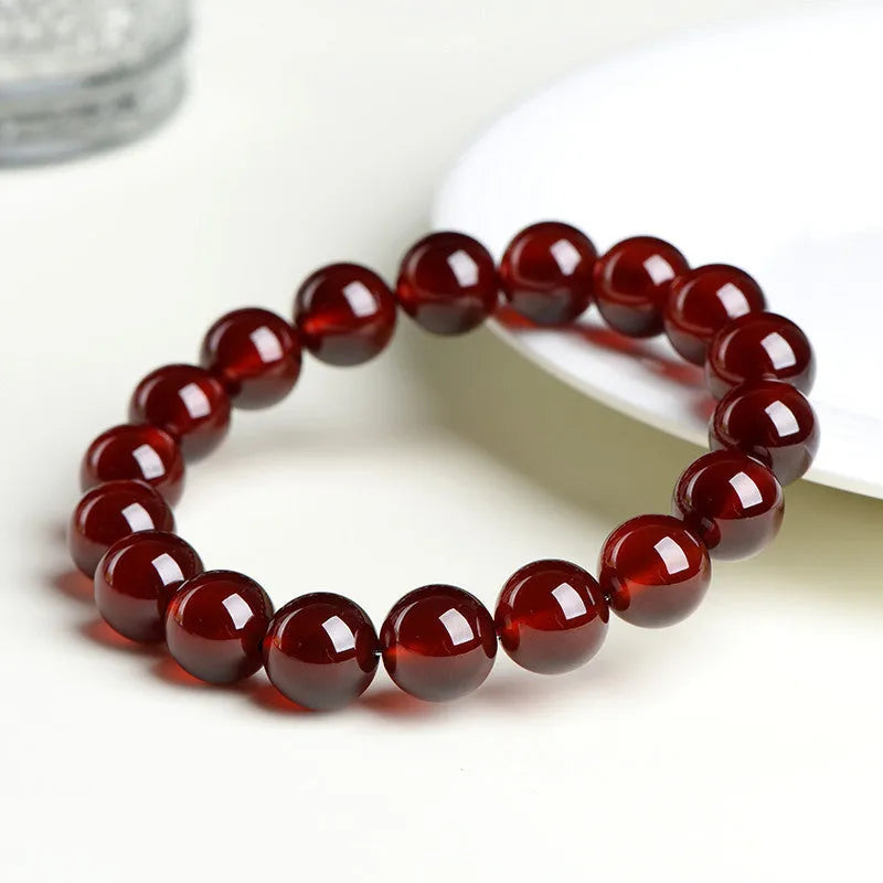 Natural orange red garnet crystal bracelet with Ruyi design elements on wrist