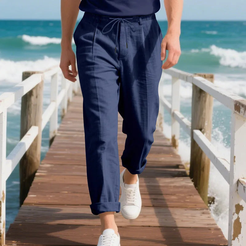 Men's light beige linen casual trousers with drawstring waist and straight-leg fit on a hanger.