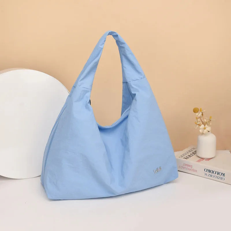 Soft nylon women's underarm bag in a heart shape, shown in black, blue, khaki, and yellow colours.