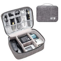 Black and grey waterproof electronics organiser bag open to show removable dividers and mesh pockets for cables.