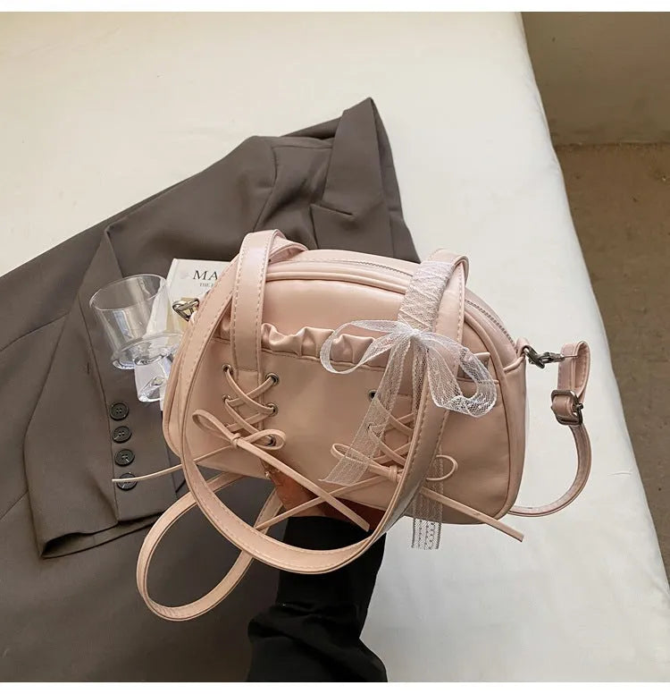 Milky white women's PU leather shoulder bag with a removable bandage bow and visible sewing thread detailing