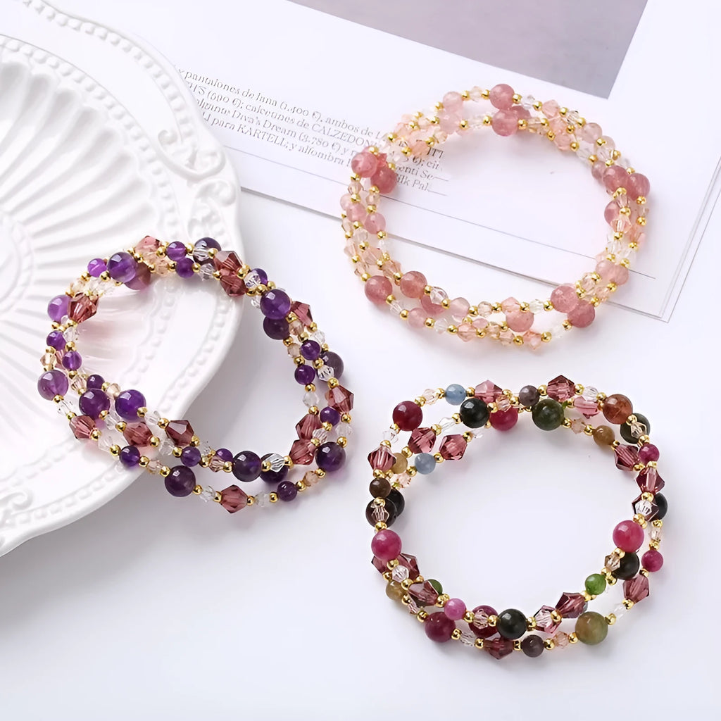 Adjustable bracelet with tourmaline, strawberry quartz, and amethyst crystals in a three-ring design.