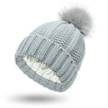 Women's black wool beanie hat with a faux fur pom pom and satin lining on a white background