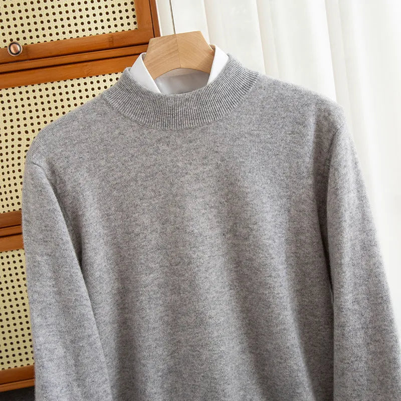 Man wearing a loose-fit, chunky knit wool sweater with a half-turtleneck collar in a neutral colour.