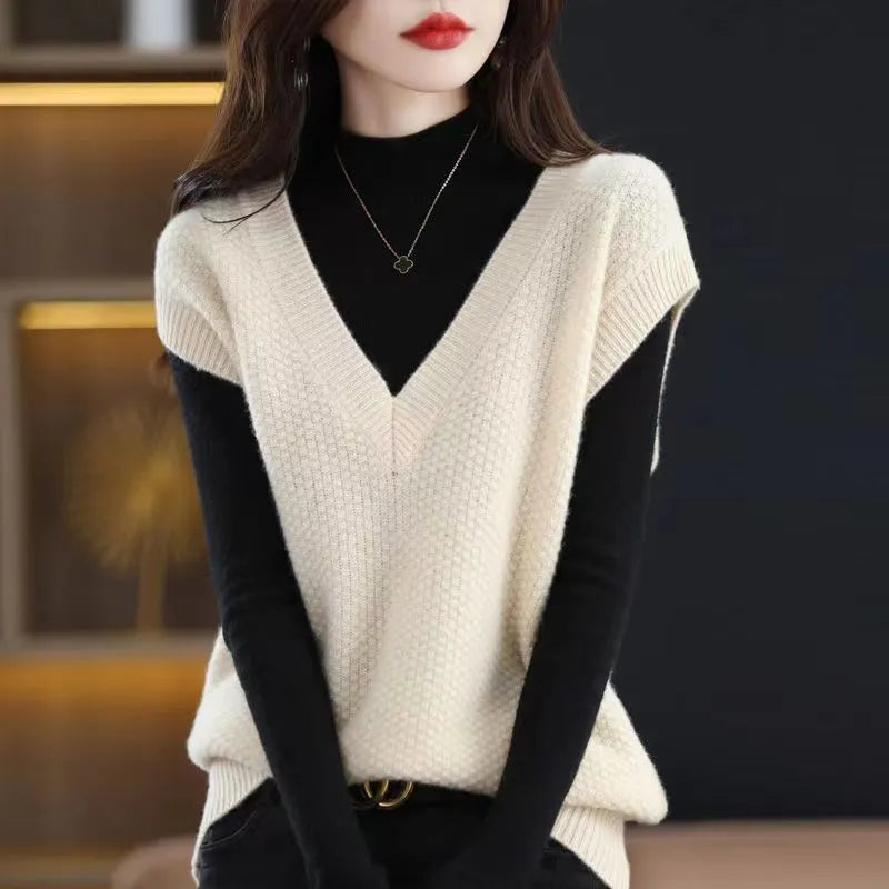 V-neck sleeveless knitted beige vest with a raised 3D pattern, laid flat.