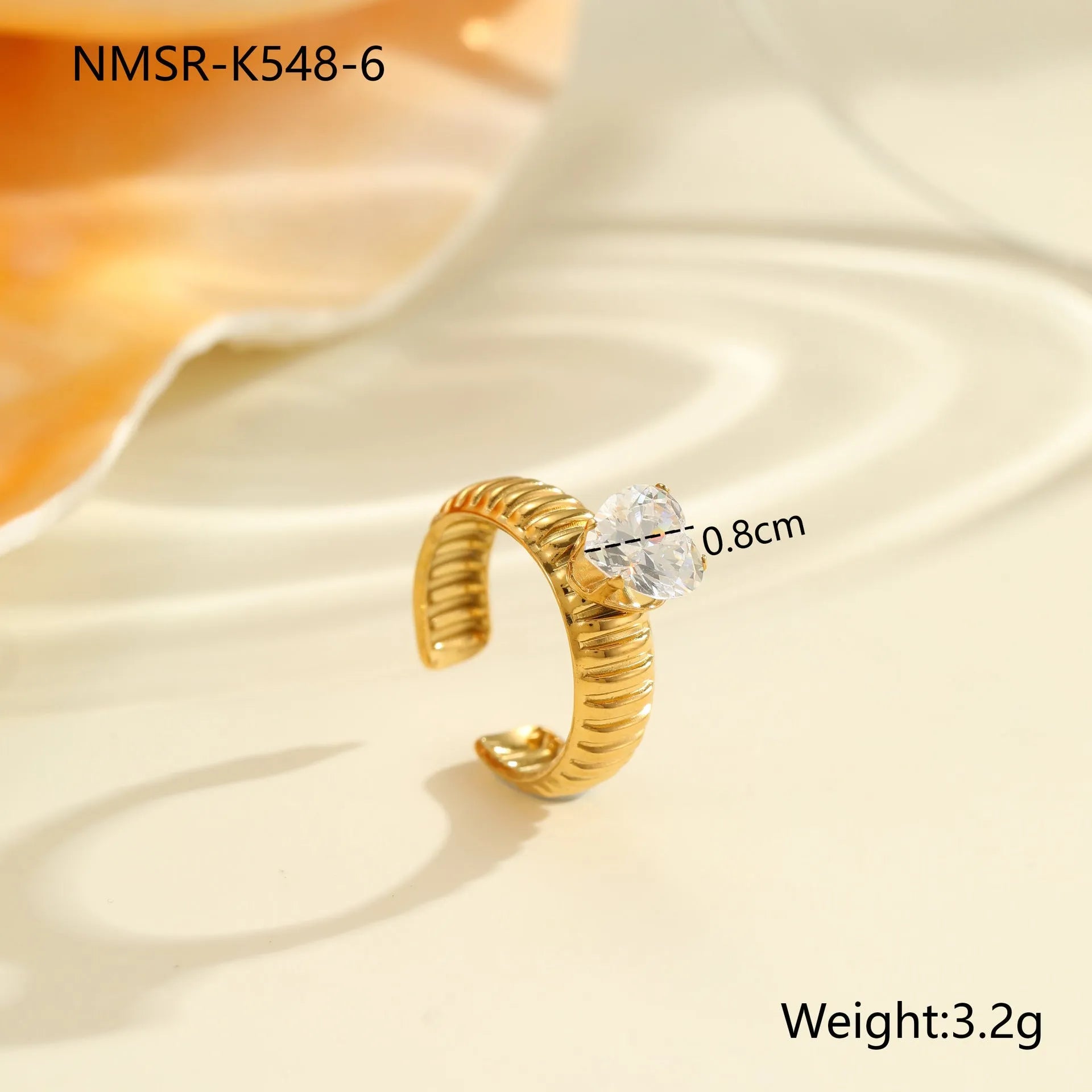Gold-plated geometric stainless steel ring with inlaid zircon stones on a white background.