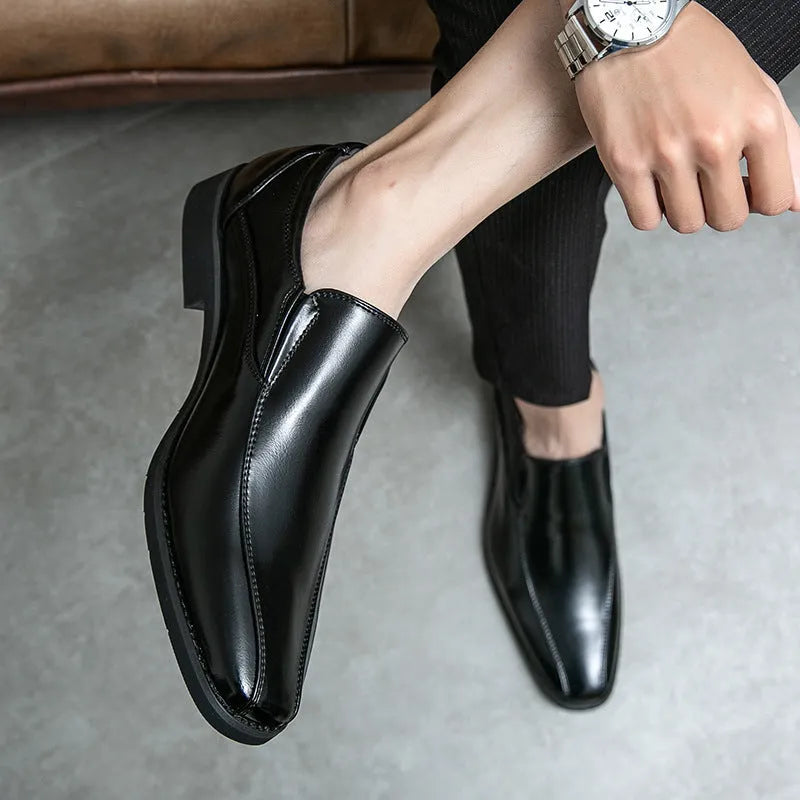 Men's black pointed casual shoes with a patent leather look and flat rubber sole.