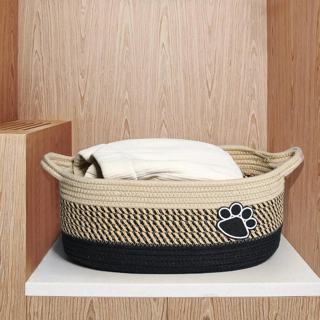Light beige handmade cotton rope storage basket with handle, shown with toys inside.
