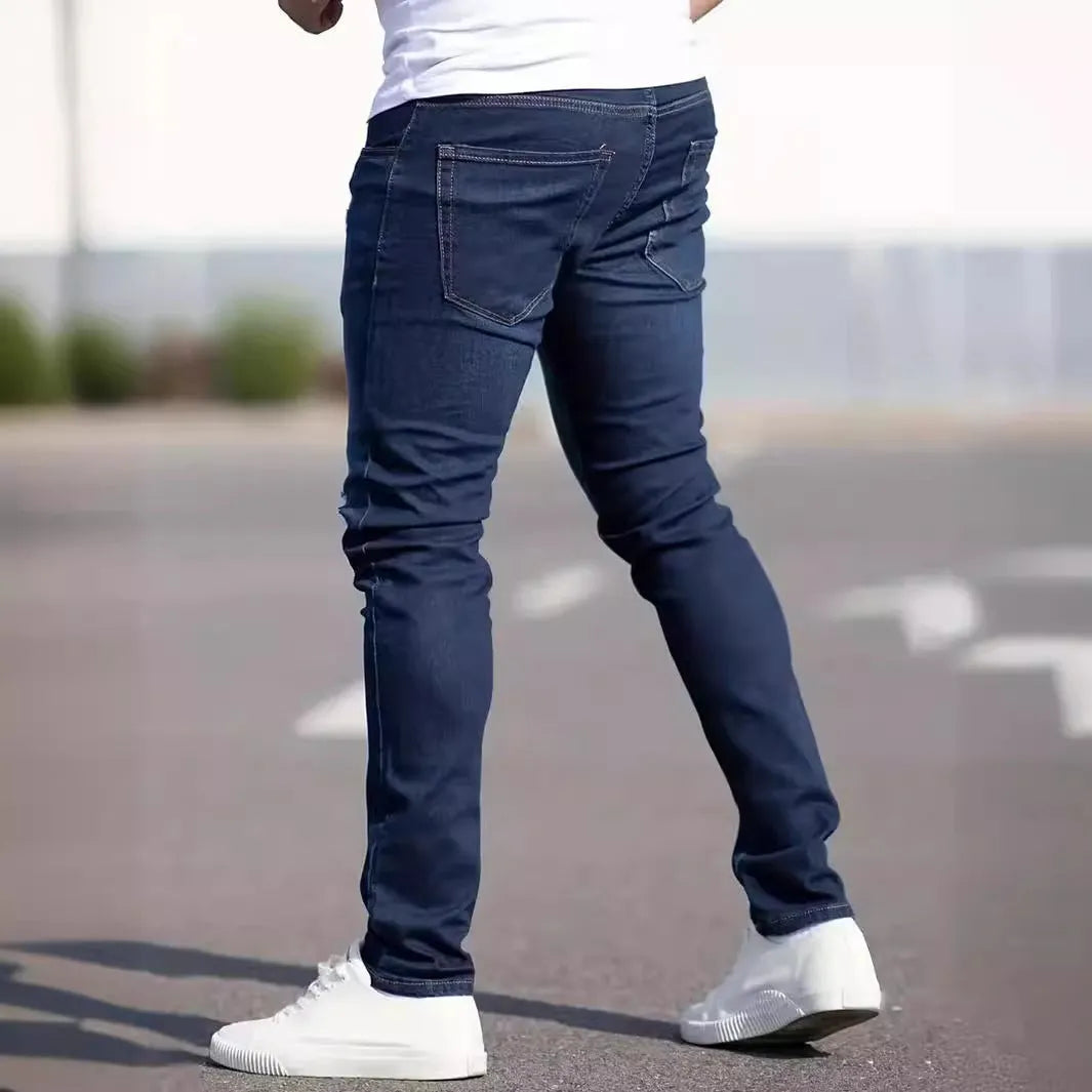 Men's dark blue slim fit skinny jeans with a mid waist and zipper fly, laid flat.
