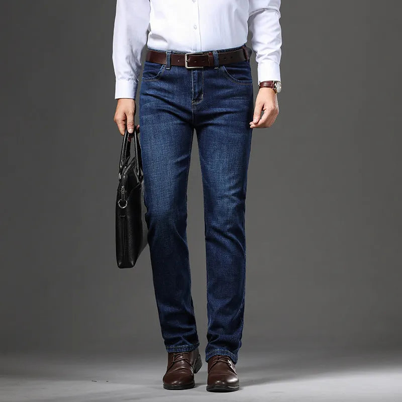 Man wearing black loose fit straight leg stretch denim jeans, showing mid waist and zip fly.