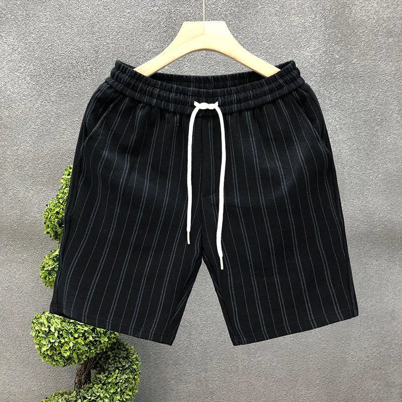 Men's black and white striped casual shorts with elastic waistband, shown on a hanger.