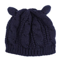 Handmade red knitted beanie with 3D cat ears on a white background