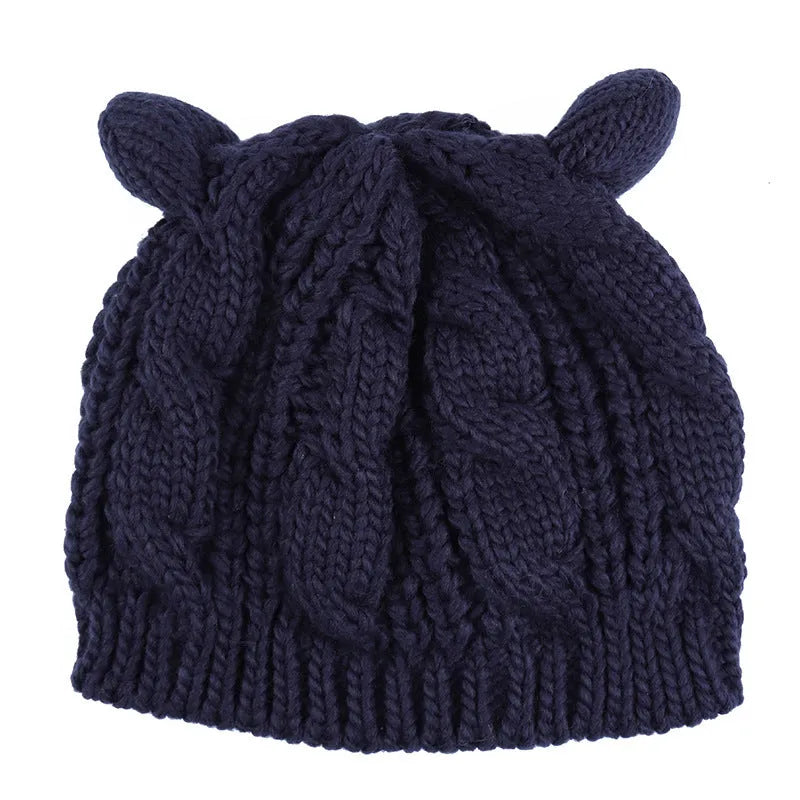 Handmade red knitted beanie with 3D cat ears on a white background