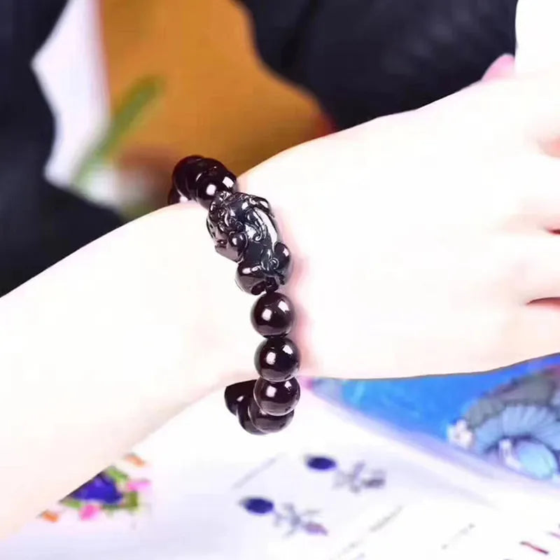 Natural ice colour eye obsidian crystal bracelet with spherical beads on a wrist.