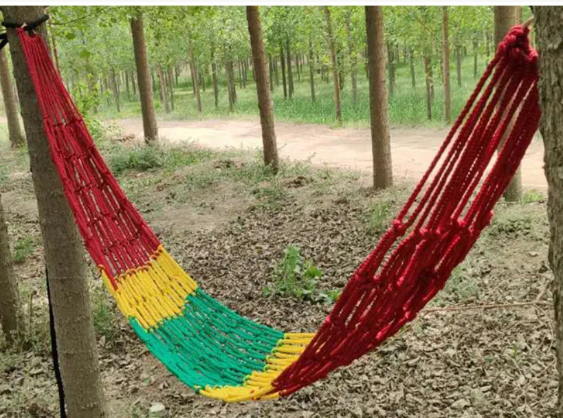 Nylon rope mesh hammock hung between trees showing open weave pattern and included tying ropes