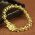 Yellow leather cord bracelet with artificial crystal beads and a Pi Xiu charm in Chinese folk style.