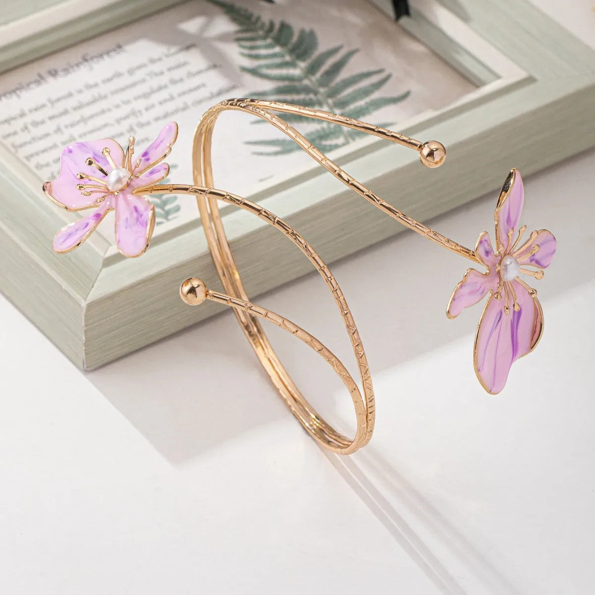 Pink alloy fashion armband with a hollow, openwork pattern shown on a wrist.