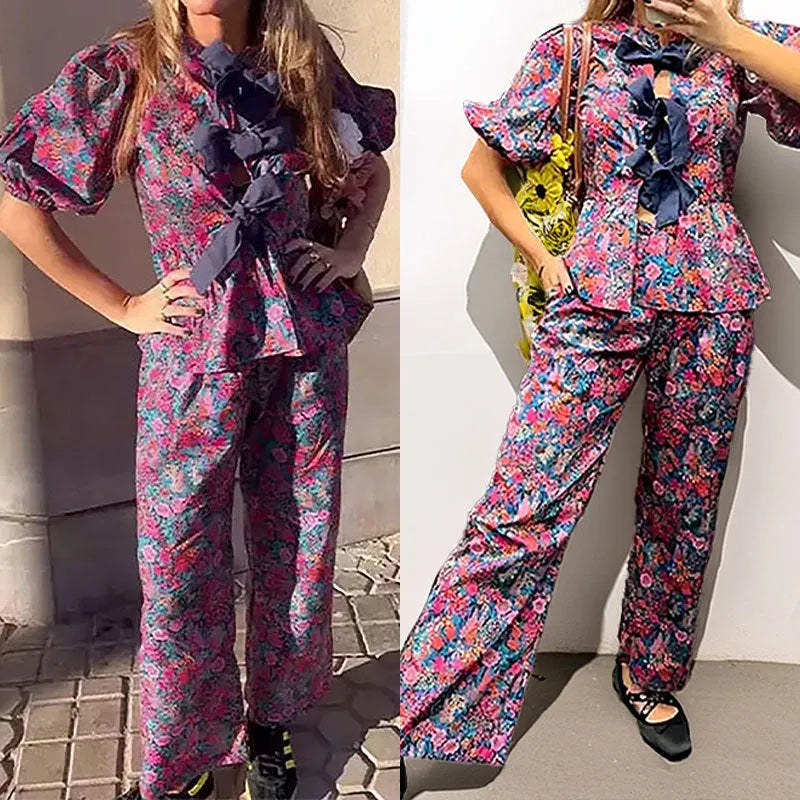 Women's floral print trouser suit set featuring a puff sleeve top with tie-neck and matching trousers.