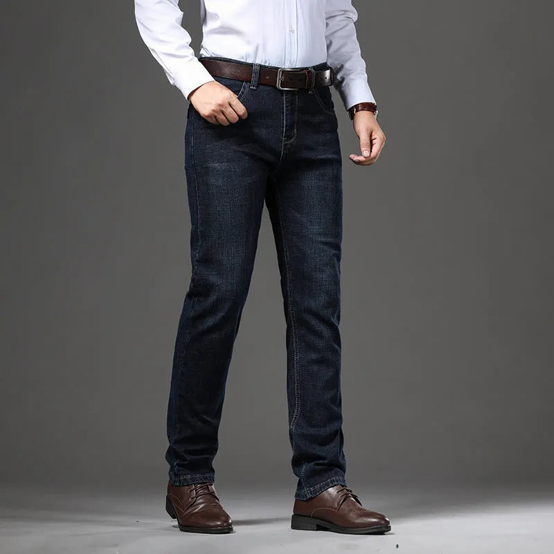 Man wearing black loose fit straight leg stretch denim jeans, showing mid waist and zip fly.