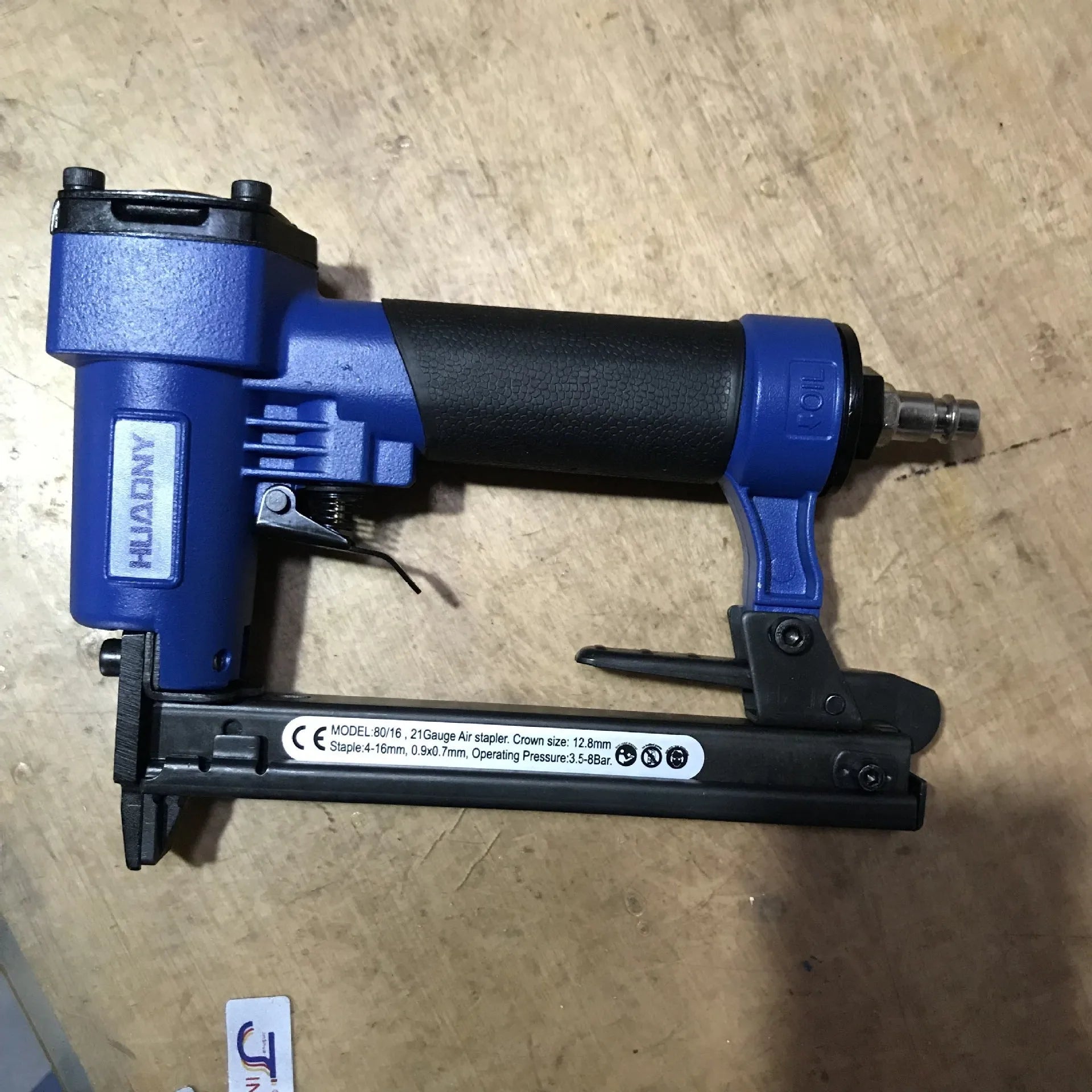 Blue and yellow U-type pneumatic strip nail gun for interior decoration and furniture work.