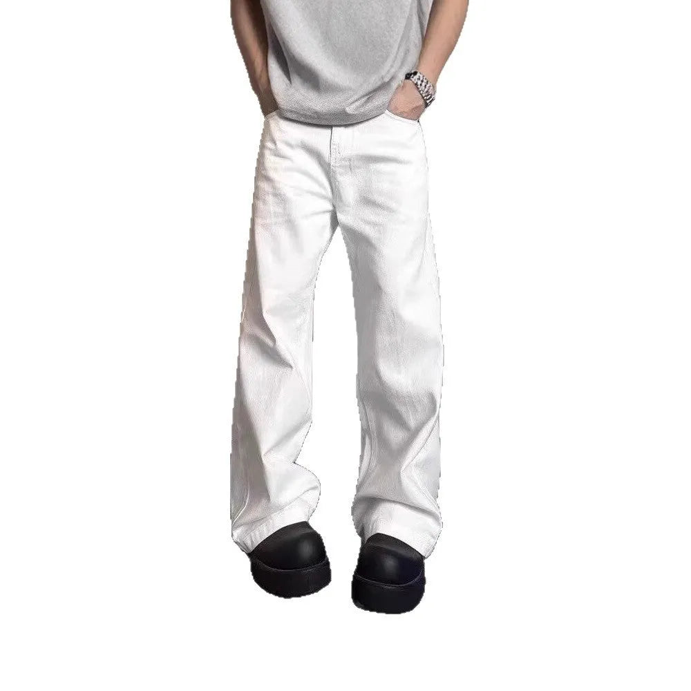 Man wearing loose straight-leg white denim jeans with a wide leg opening.