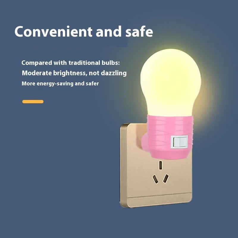 Plug-in bedside baby night light in white, blue, or pink shell on a nursery table.