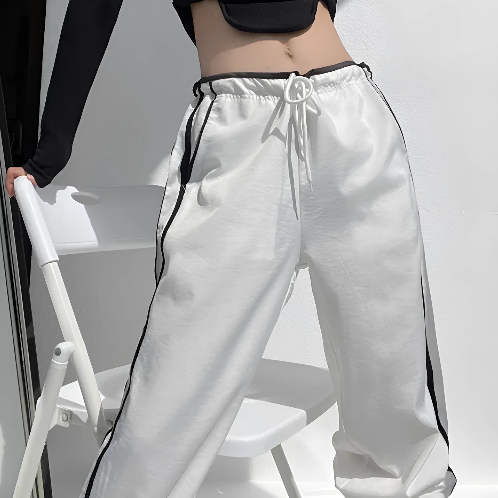 Women's navy blue loose straight-leg trousers with thin fabric and ribbon parallel bars contrast detail.