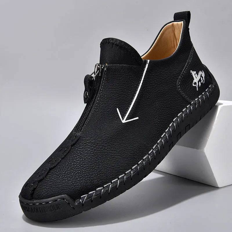 Men's brown leather boots with front zip closure and hand-stitched rubber soles