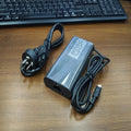 Black 65W USB-C laptop power adapter with six international travel plug cords.