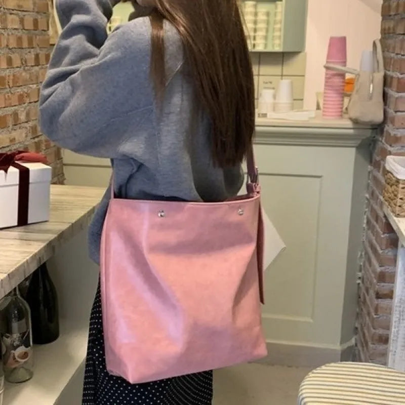 Pink corduroy one-shoulder commuter bag with a single strap and PU lining.