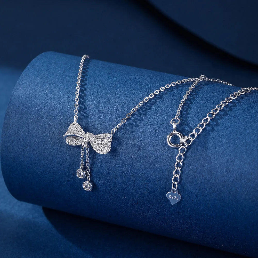 S925 sterling silver bow pendant necklace with O-ring chain on grey background