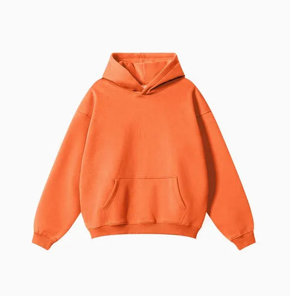 Man wearing a loose-fit grey cotton terry hooded sweater with drop-shoulder sleeves.