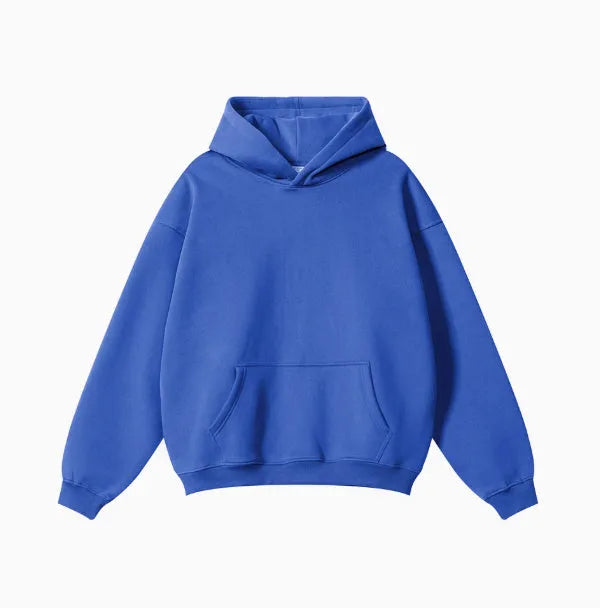 Man wearing a loose-fit grey cotton terry hooded sweater with drop-shoulder sleeves.