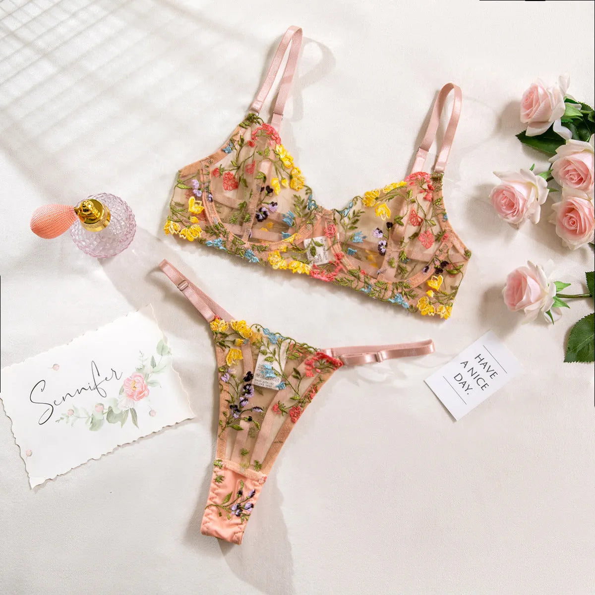 Floral patterned mesh bra with steel ring T-back in various colours on a mannequin.